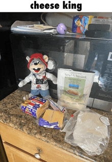 a chuck e cheese stuffed animal sitting on a counter next to a bag of mozzarella cheese