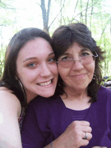 two women posing for a picture with one wearing a ring on her finger