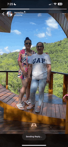 two women standing next to each other with one wearing a gap t-shirt