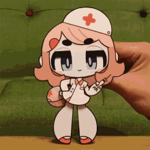 a paper doll of a nurse with a red cross on her cap