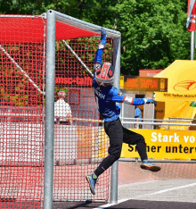 a soccer goalie is jumping in the air in front of a sign that says stark vor stern unter