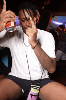 a man in a white shirt holds a can of soda