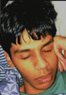 a young man laying down with his eyes closed