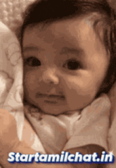 a picture of a baby with the website starttamilchat.in written on the bottom