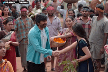 a man in a blue shirt is shaking hands with a woman in a crowd