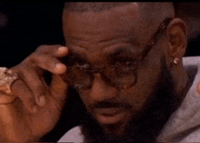 a man with a beard is wearing glasses and holding something in his hand