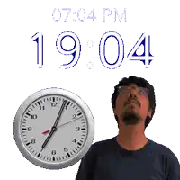 a man is standing in front of a clock that says 19:04