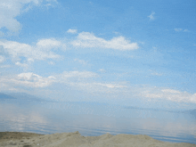 a large body of water with a blue sky and clouds