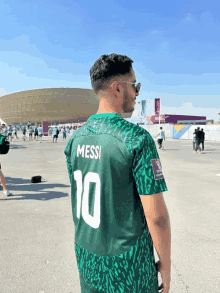 a man wearing a green jersey that says messi on it