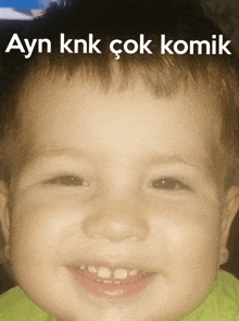 a baby with a green shirt is smiling with ayn knk çok komik written on the top