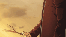 a man in a brown coat is holding a stick in his right hand