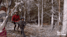 a man in a red uniform is carrying a child in a snowy forest with the words heart & home on the bottom right