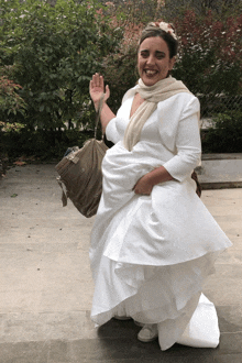 a woman in a white dress is holding a purse