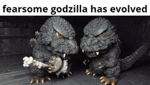 two figurines of godzilla are standing next to each other with the caption " fearsome godzilla has evolved "