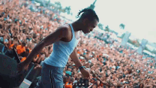 a man in a white tank top is standing in front of a crowd and the word flow is on the bottom left