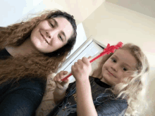 a woman and a little girl are holding toothbrushes