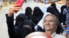 a man is taking a selfie with a woman wearing a niqab