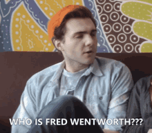 a man sitting on a couch with the words who is fred wentworth behind him