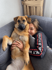 a girl with a truth is the only way sweatshirt hugging a brown dog