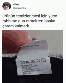 a person holding a label that says ' rabbime dua etmekten başka carem kalmadi '