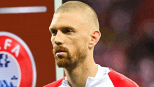 a man with a beard is standing in front of an uefa logo