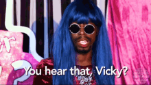 a man with blue hair and sunglasses is asking you hear that vicky