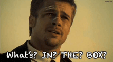 a man in a suit and tie is asking " what 's in the box "