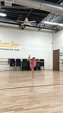 a little girl is doing a split in a dance studio that says center stage