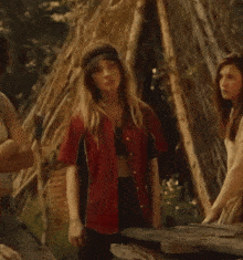 a woman in a red shirt is standing next to another woman