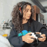 a woman is wearing headphones and playing a video game .