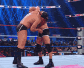 two men are wrestling in a ring with the letter w on the ring