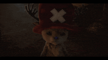 a stuffed animal wearing a red hat with a white cross on it
