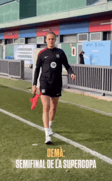 a woman walking on a soccer field with the words " dema semifinal de la supercopa " on the bottom