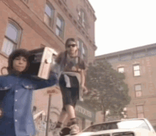 two people carrying boxes on their shoulders are standing on top of a car in front of an antiques store