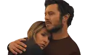 a man with a beard is hugging a woman with a sad look on her face
