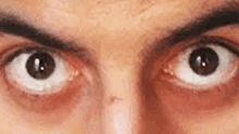 a close up of a man 's eyes with a smirk on his face .