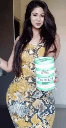 a woman in a snake print dress holds a container of power gummies