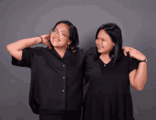 two women are posing for a picture and one has a tattoo on her arm that says ' i love you '