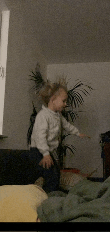 a little girl in a white jacket is jumping in the air