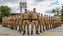 a large group of soldiers are standing in a line in front of a building .