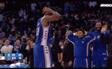 a basketball player with the number 21 on his jersey stands in front of a crowd