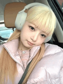 a young woman wearing headphones is sitting in a car .