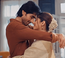 a man is holding a woman in his arms and they are hugging each other