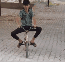 a young boy is riding a pink bicycle with his legs crossed