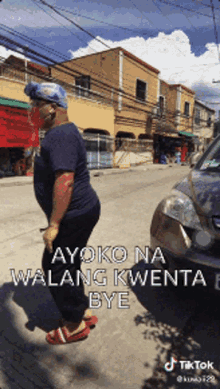 a man wearing a helmet is walking down a street with the words ayoko na walang kwenta bye written on the bottom