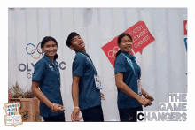 a group of young people are posing for a photo in front of a sign that says youth olympic games