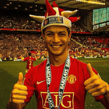 a man wearing a hat and a medal that says aig gives a thumbs up