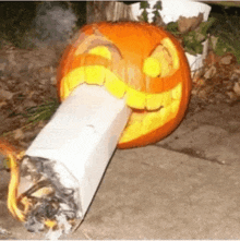 a pumpkin carved to look like a cigarette with a smiling face