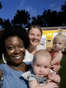 a woman is holding a baby in her arms and smiling