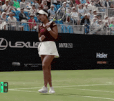 a woman holding a tennis racquet on a tennis court with a sign that says wta 250 in the background